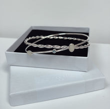 Load image into Gallery viewer, bespoke sterling silver bangle made with two oval breastmilk charms and blue topaz birthstone
