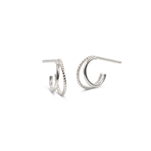 Load image into Gallery viewer, A pair of silver-toned textured double hoop earrings with post backings, displayed on a clean white background.
