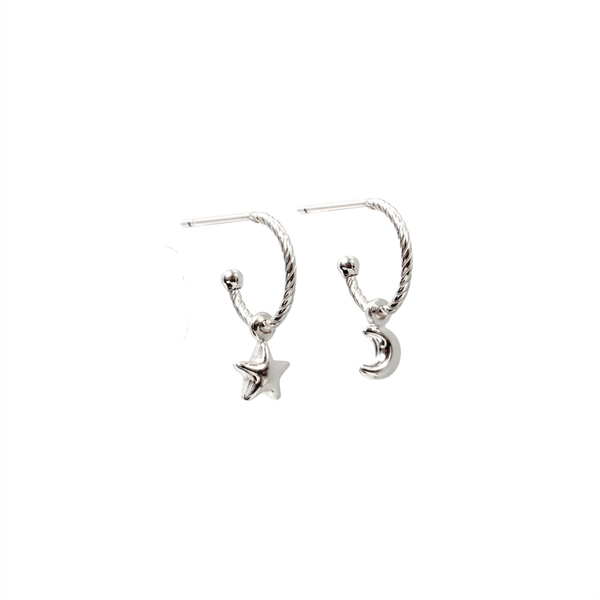 A pair of silver-toned twisted hoop earrings, one featuring a dangling star charm and the other a crescent moon charm, shown on a plain white background.